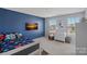 Cozy bedroom with a blue accent wall, lots of natural light, and neutral carpeting at 7332 Newsome Sw Ct, Concord, NC 28025