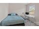 This bedroom features a bed and an office setup with an ergonomic chair and a bright window at 7332 Newsome Sw Ct, Concord, NC 28025