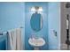 Cozy half bathroom featuring a pedestal sink, decorative mirror, and blue accent wall at 7332 Newsome Sw Ct, Concord, NC 28025