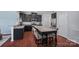 Kitchen featuring dark wood cabinets, stainless steel appliances, and a granite-topped kitchen island at 7332 Newsome Sw Ct, Concord, NC 28025