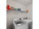 A tidy laundry room equipped with a modern washer and dryer and shelving for storage of laundry supplies at 7332 Newsome Sw Ct, Concord, NC 28025