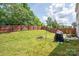 Spacious backyard with fire pit, swing set, and mature trees at 937 Anchor Ne Way, Kannapolis, NC 28083