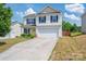 Two-story home with blue shutters, yellow door, and two-car garage on a sunny day at 937 Anchor Ne Way, Kannapolis, NC 28083