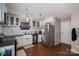 Kitchen with stainless steel refrigerator, white cabinets, farmhouse sink, and hardwood floors at 937 Anchor Ne Way, Kannapolis, NC 28083