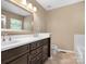 Bathroom featuring dual sinks, dark cabinetry, and a large mirror at 9430 Peckham Rye Rd, Mint Hill, NC 28227
