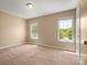 Bedroom with wall-to-wall carpeting, two windows, and a door at 9430 Peckham Rye Rd, Mint Hill, NC 28227