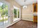 Eat-in kitchen area boasts bay window, door to yard, hardwood floors, and modern chandelier at 9430 Peckham Rye Rd, Mint Hill, NC 28227