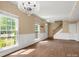 Spacious living room with hardwood floors, wainscoting, staircase and abundant natural light from large windows at 9430 Peckham Rye Rd, Mint Hill, NC 28227