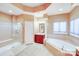 Luxurious bathroom with a glass-enclosed shower, garden tub, vanity with cabinets, and a large window at 9433 Stonebridge Way, Mint Hill, NC 28227