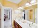 Bright bathroom features a double sink vanity, large mirror, and a view into the bedroom and shower room at 9433 Stonebridge Way, Mint Hill, NC 28227