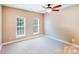 A neutral bedroom with carpet, two windows, and a ceiling fan at 9433 Stonebridge Way, Mint Hill, NC 28227