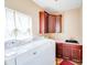 Well-lit laundry room features a window, cabinetry, sink, countertop and modern white washer and dryer at 9433 Stonebridge Way, Mint Hill, NC 28227