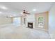 Bright living room featuring a cozy fireplace, ceiling fan, and neutral color palette at 9433 Stonebridge Way, Mint Hill, NC 28227