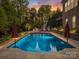 Enjoy a serene evening swim in this luxurious pool featuring ambient lighting and comfortable lounge seating at 9433 Stonebridge Way, Mint Hill, NC 28227