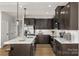 Well-lit kitchen featuring an island with bar seating, modern appliances, and stylish cabinetry at 9527 Teamwork Nw St, Concord, NC 28027