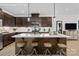 Modern kitchen features a large island with seating and pendant lighting, and dark wood cabinetry at 9527 Teamwork Nw St, Concord, NC 28027