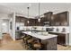 Open kitchen with stainless steel appliances, a central island, and dark wood cabinets offering ample storage at 9527 Teamwork Nw St, Concord, NC 28027