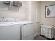 Laundry room with a washer, dryer, wire rack shelving, and black framed print at 9527 Teamwork Nw St, Concord, NC 28027
