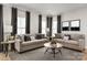 Living room featuring comfortable sofas, stylish decor, and natural light from large windows at 9527 Teamwork Nw St, Concord, NC 28027