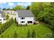 Aerial view of the backyard with lawn, gardens, and access to a covered patio and green trees at 9596 Pacing Nw Ln, Concord, NC 28027