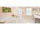 Bright bathroom with a soaking tub, glass shower, white tiling, and plantation shutters at 9596 Pacing Nw Ln, Concord, NC 28027