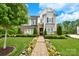Beautiful two-story home with stone accents, manicured lawn, and a colorful flower-lined walkway at 9596 Pacing Nw Ln, Concord, NC 28027