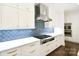 Modern kitchen with white cabinetry, stainless steel appliances, and a blue tiled backsplash at 9596 Pacing Nw Ln, Concord, NC 28027