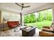 Inviting covered patio featuring a stone floor, ceiling fan, and a cozy fire pit overlooking the backyard at 9596 Pacing Nw Ln, Concord, NC 28027