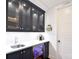 Modern wet bar featuring black cabinets, a beverage fridge, and sink at 9596 Pacing Nw Ln, Concord, NC 28027