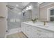 Elegant bathroom featuring a marble-tiled wall, double vanity, and glass-enclosed shower with gold fixtures at 10125 Bethel Church Rd, Midland, NC 28107