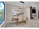 Dining area showcasing modern light fixture, large windows, fireplace, and a mirrored wall at 10125 Bethel Church Rd, Midland, NC 28107