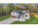 Attractive home with white exterior, black trim, and inviting entryway with stone steps and stylish details at 10125 Bethel Church Rd, Midland, NC 28107