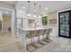 Modern kitchen features a marble island with seating, stainless steel appliances and elegant pendant lighting at 10125 Bethel Church Rd, Midland, NC 28107