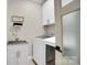 Bright laundry room with stainless steel sink, modern washer and dryer, and storage cabinets at 10125 Bethel Church Rd, Midland, NC 28107