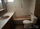 A pink bathroom with a sink, bathtub, and toilet needs updates and repairs to restore its appeal at 1029 Sullivan St, Wadesboro, NC 28170