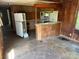 A full view of the kitchen and dining area showing the refrigerator and bar top needing repairs at 1029 Sullivan St, Wadesboro, NC 28170