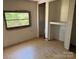 Incomplete room with a window offering outdoor views and outdated flooring that awaits renovation at 1029 Sullivan St, Wadesboro, NC 28170