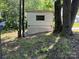 Storage shed between a telephone pole and a large tree on a grassy yard at 1029 Sullivan St, Wadesboro, NC 28170