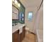 Stylish bathroom featuring a modern vanity, mirror, and shower/tub combination with window at 106 Greentree Dr, Mount Holly, NC 28120