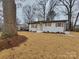 Charming one-story home with white brick, light blue door, and a well-manicured lawn at 106 Greentree Dr, Mount Holly, NC 28120