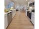 Bright kitchen with stainless steel appliances, white cabinetry and modern countertops open to dining and living area at 106 Greentree Dr, Mount Holly, NC 28120