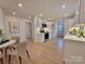 Open concept dining and kitchen with light wood floors and white walls at 106 Greentree Dr, Mount Holly, NC 28120