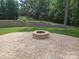 Beautiful backyard featuring a stone fire pit and patio, with landscaping and retaining wall at 1071 Bassett Way, Fort Mill, SC 29707