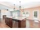 Granite kitchen island with sink, dishwasher, wood cabinets, and pendant lighting at 1071 Bassett Way, Fort Mill, SC 29707