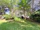 Exterior back view showing the side of the home, a small fence, mature landscaping, and large trees at 10804 Back Ridge Rd, Charlotte, NC 28277