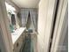 Bathroom featuring tile floors, a double sink vanity with a marble countertop, and a tub with a decorative shower curtain at 10804 Back Ridge Rd, Charlotte, NC 28277