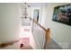 Staircase with wooden handrail and white banisters, leading to the upper level, illuminated by a chandelier at 10804 Back Ridge Rd, Charlotte, NC 28277