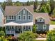 Scenic aerial view of a two-story home with a charming front porch, surrounded by lush greenery and mature trees at 10822 Brandie Meadow Ln, Huntersville, NC 28078
