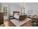 Elegant main bedroom with a wooden sleigh bed, neutral rug, and chandelier lighting at 10822 Brandie Meadow Ln, Huntersville, NC 28078