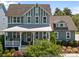 Charming two-story home with a welcoming front porch and beautifully landscaped front yard and attractive green and white color scheme at 10822 Brandie Meadow Ln, Huntersville, NC 28078
